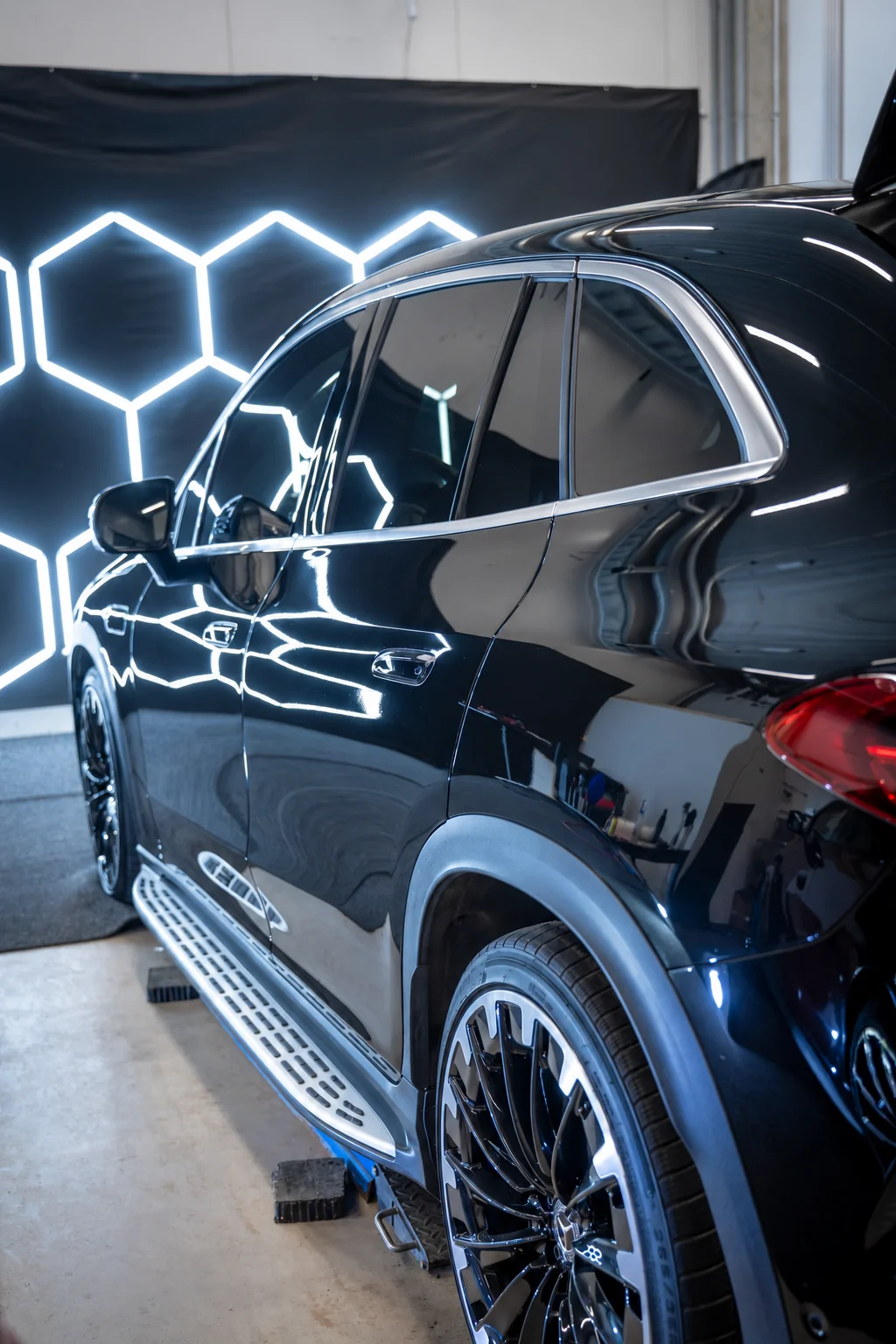 Mustan auton sivuikkunat MH-Autocleanin työtilassa